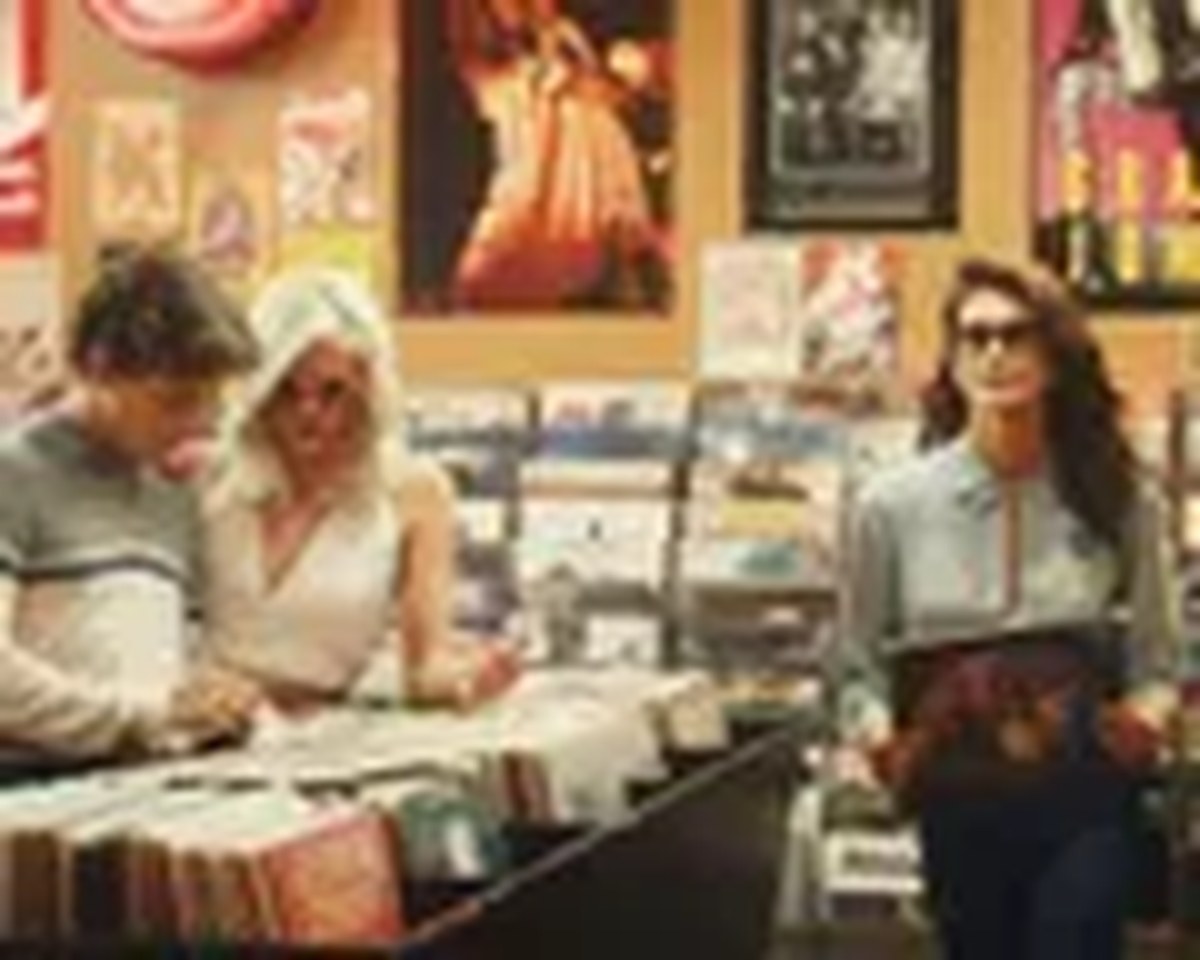 Three young people browse vinyl records in a record store with posters on the walls