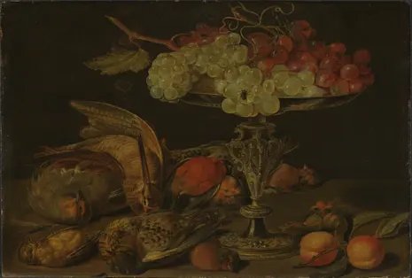 Clara Peeters' still life shows dead birds, fruit, and grapes piled on a gilded tazza