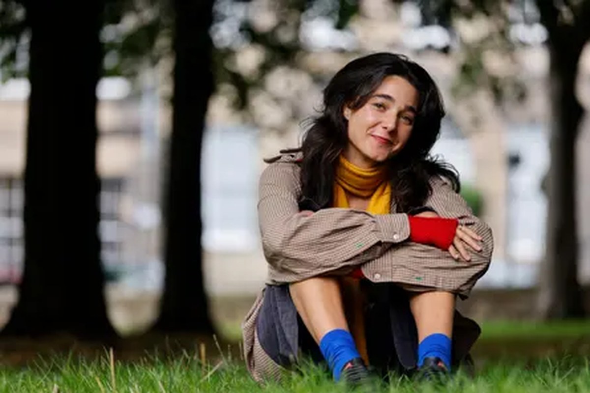 Lara Ricote sitting in a park under trees
