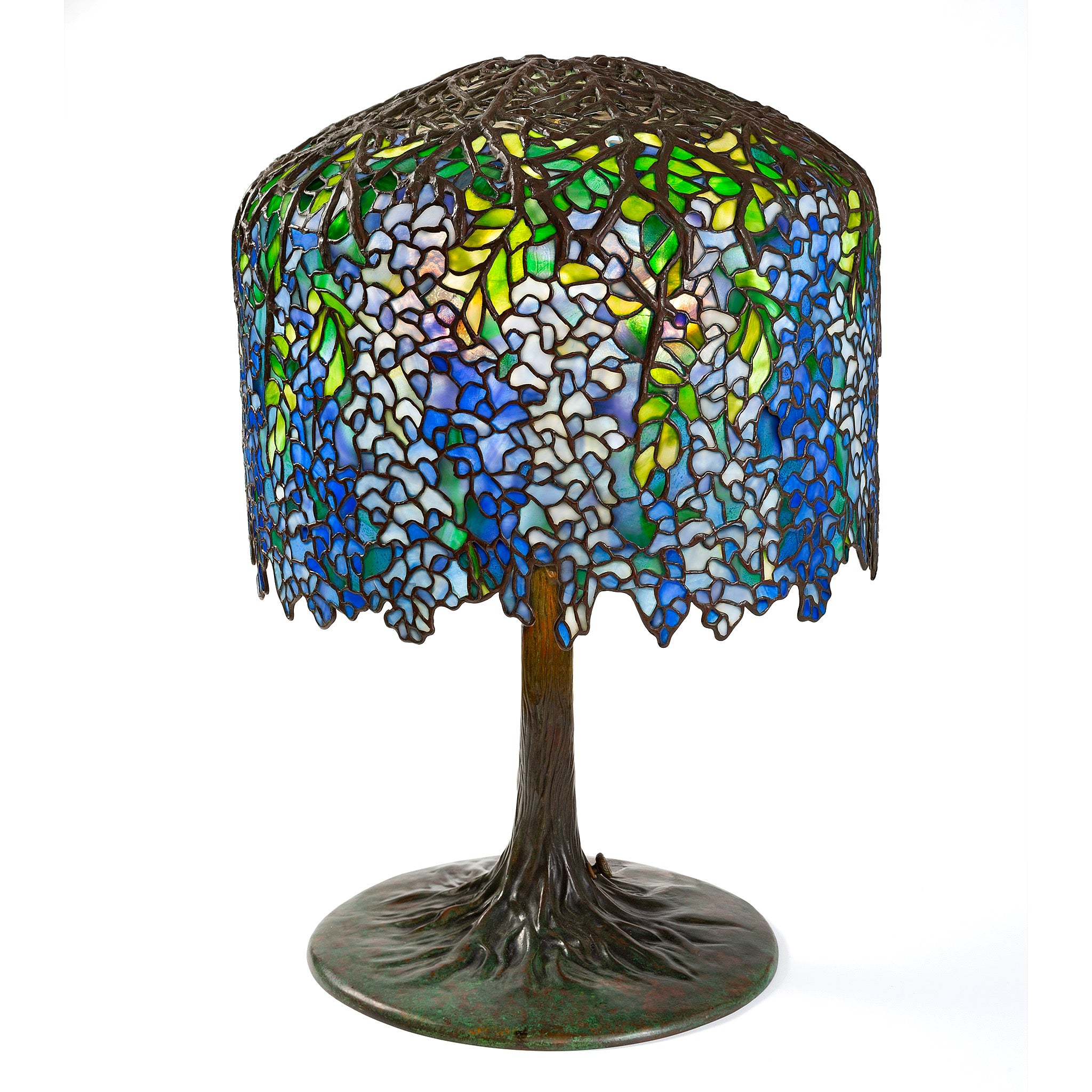 Tiffany Wisteria table lamp features cascading blue and white stained-glass blossoms above bronze tree-like base elegantly.