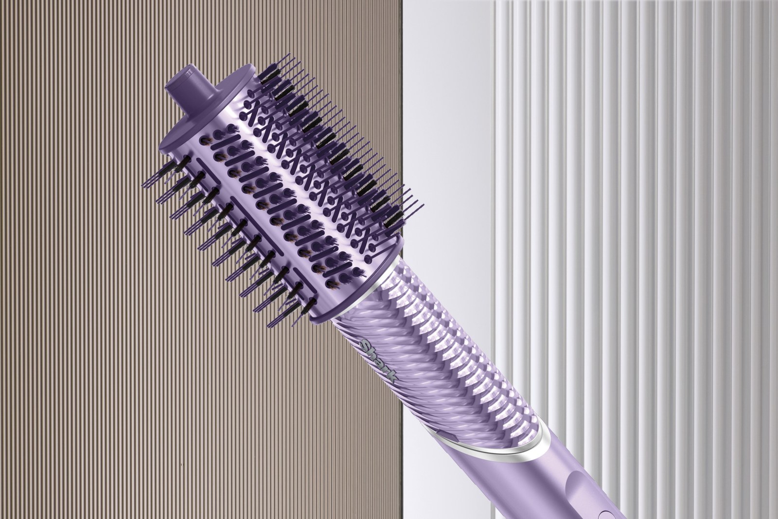 A close-up of a purple rotating hot air brush for hair styling, reminiscent of the Shark FlexStyle IonCurl, featuring bristles and a textured handle, set against a striped background.
