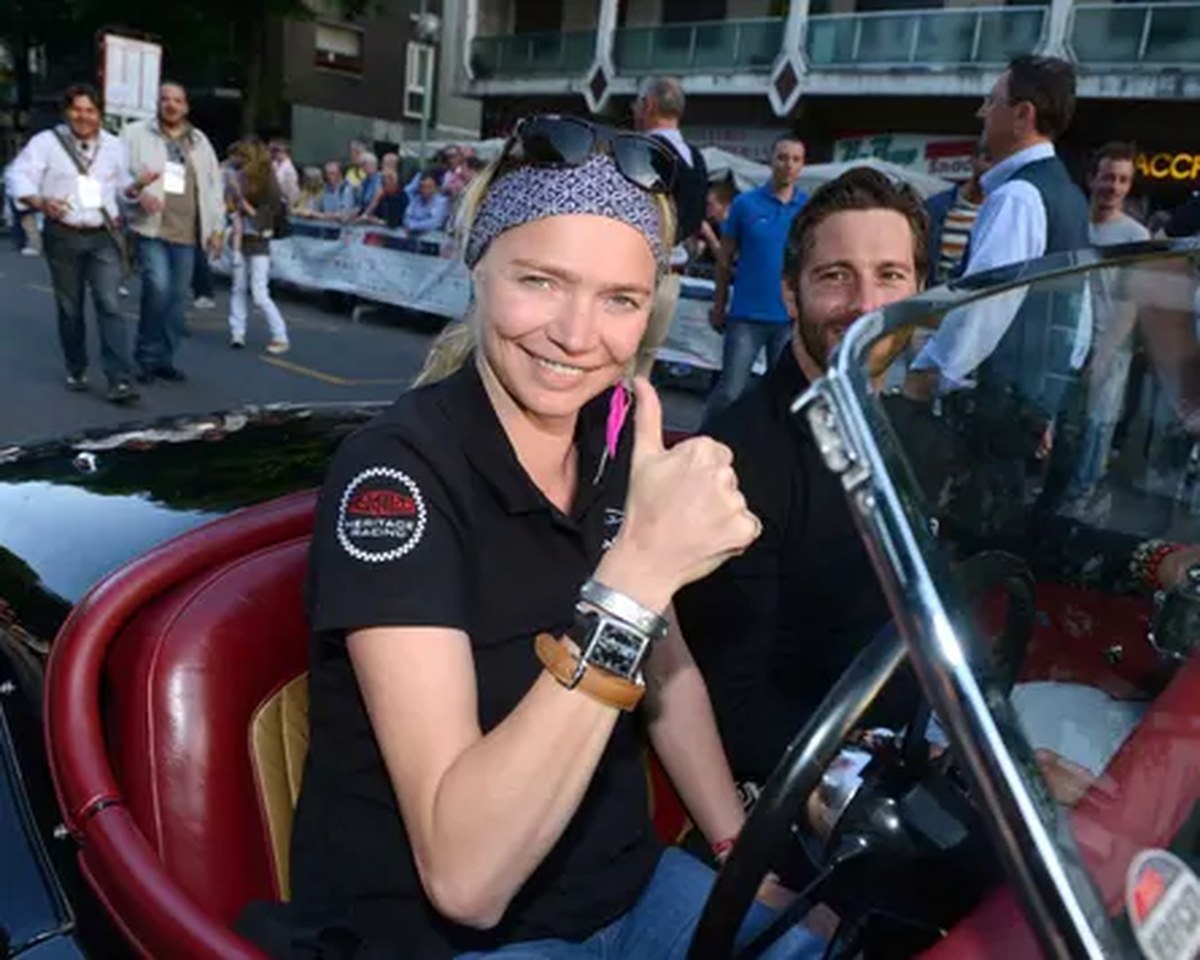 Jodie Kidd smiles and gives a thumbs-up sign as she sits in a vintage car’s driving seat