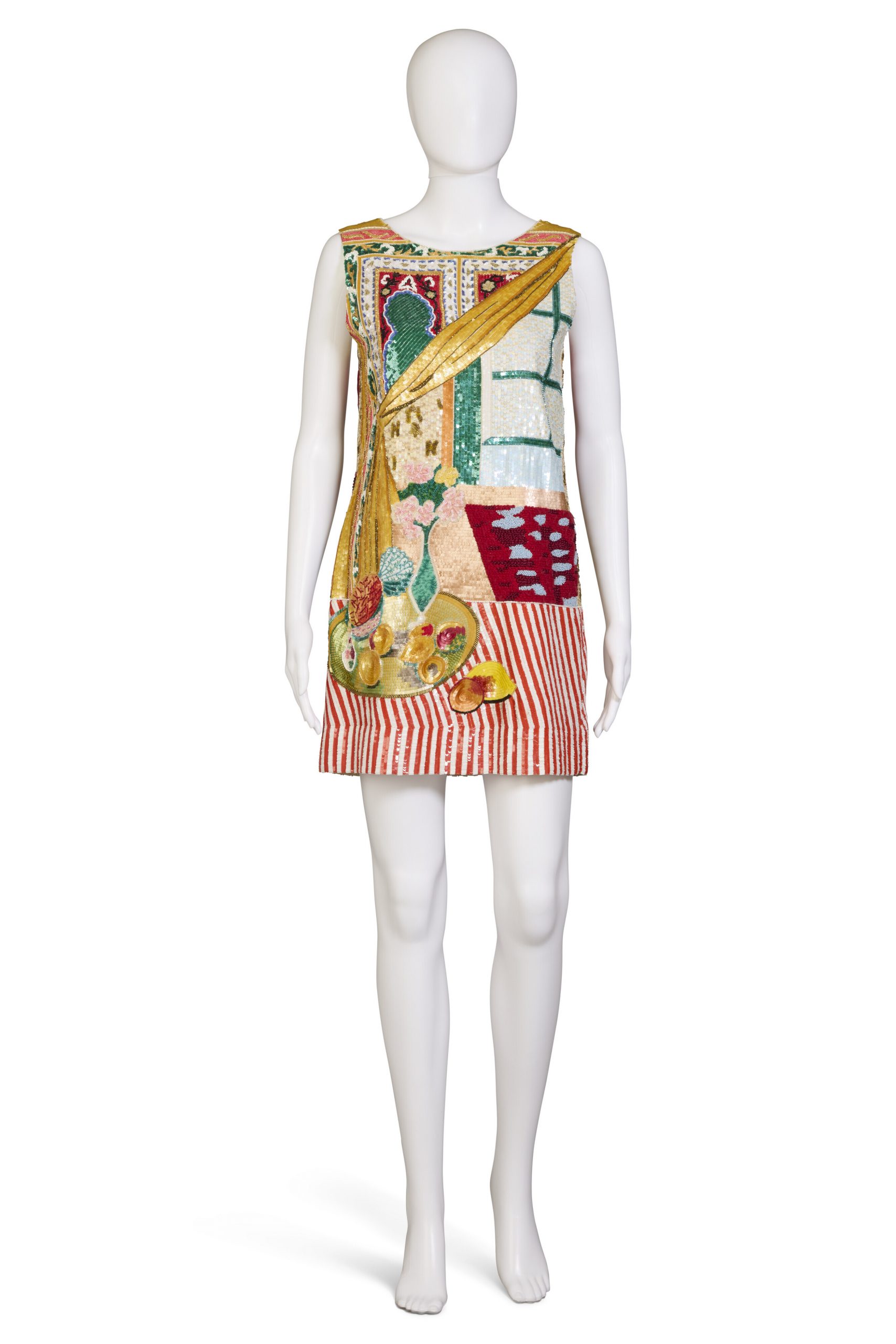 A photograph depicting a white mannequin wearing a short, colorful Bill Blass dress against an all-white background