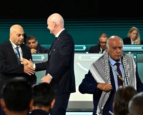 Jibril Rajoub, president of the Palestinian Football Association, walks off stage after refusing a photo with IFA vice-president Basim Sheikh Suliman (left) that was set up by Gianni Infantino (centre)