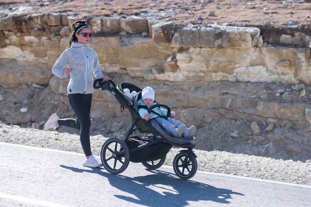 A woman jogging while pushing a stroller