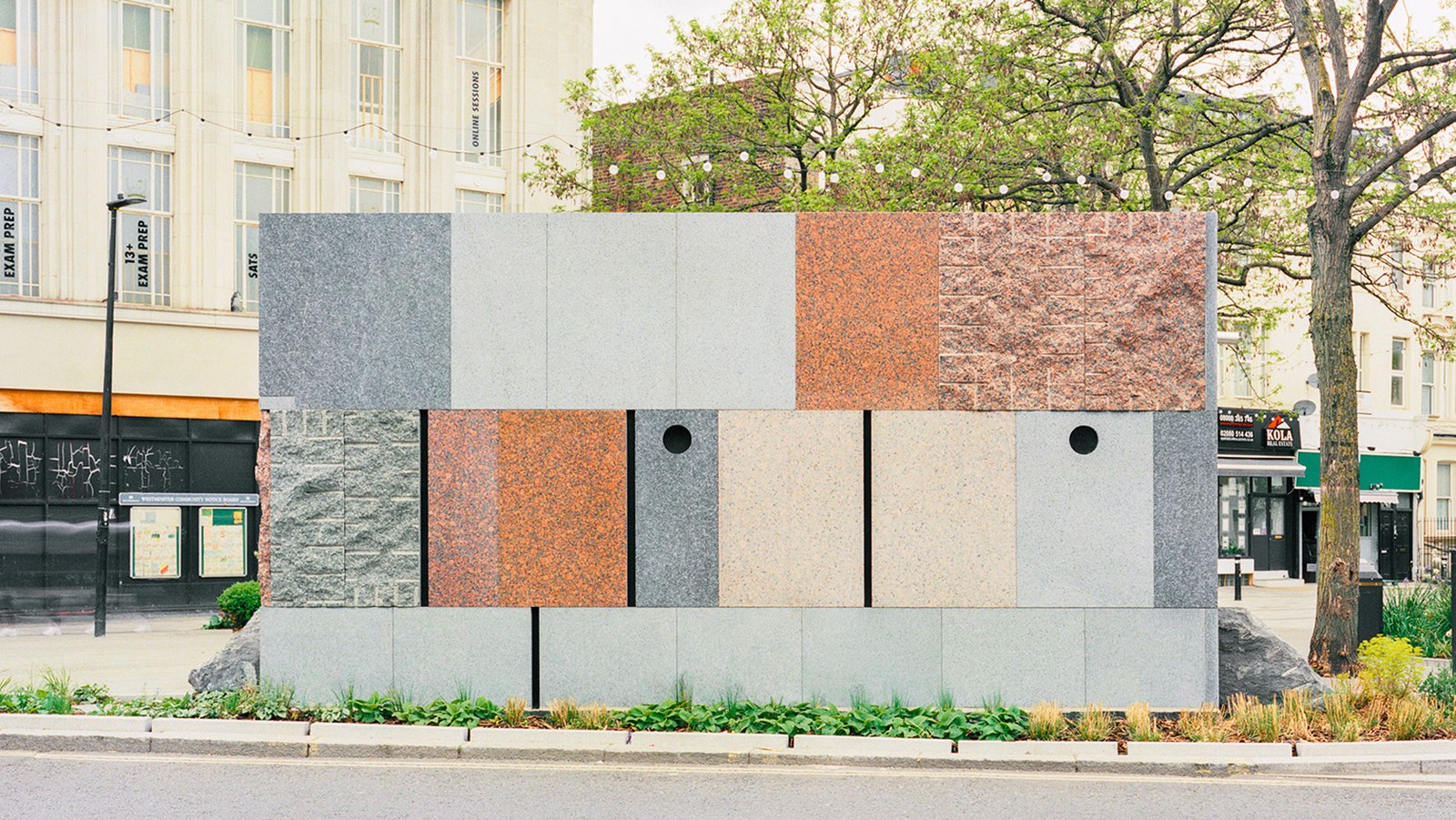exterior patchwork effect of public toilet in Maida Vale by Studio Weave, seen by a tree