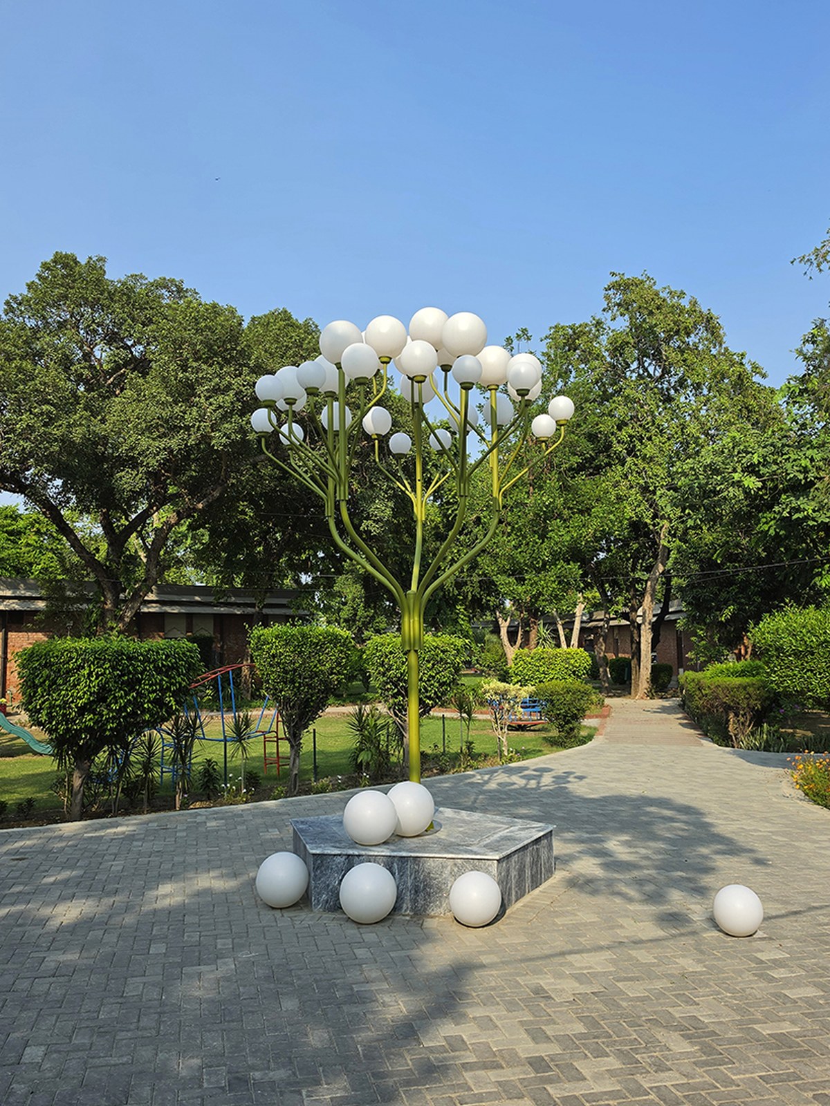 luminous globes extend from branched metal tree installation in pakistan - 1