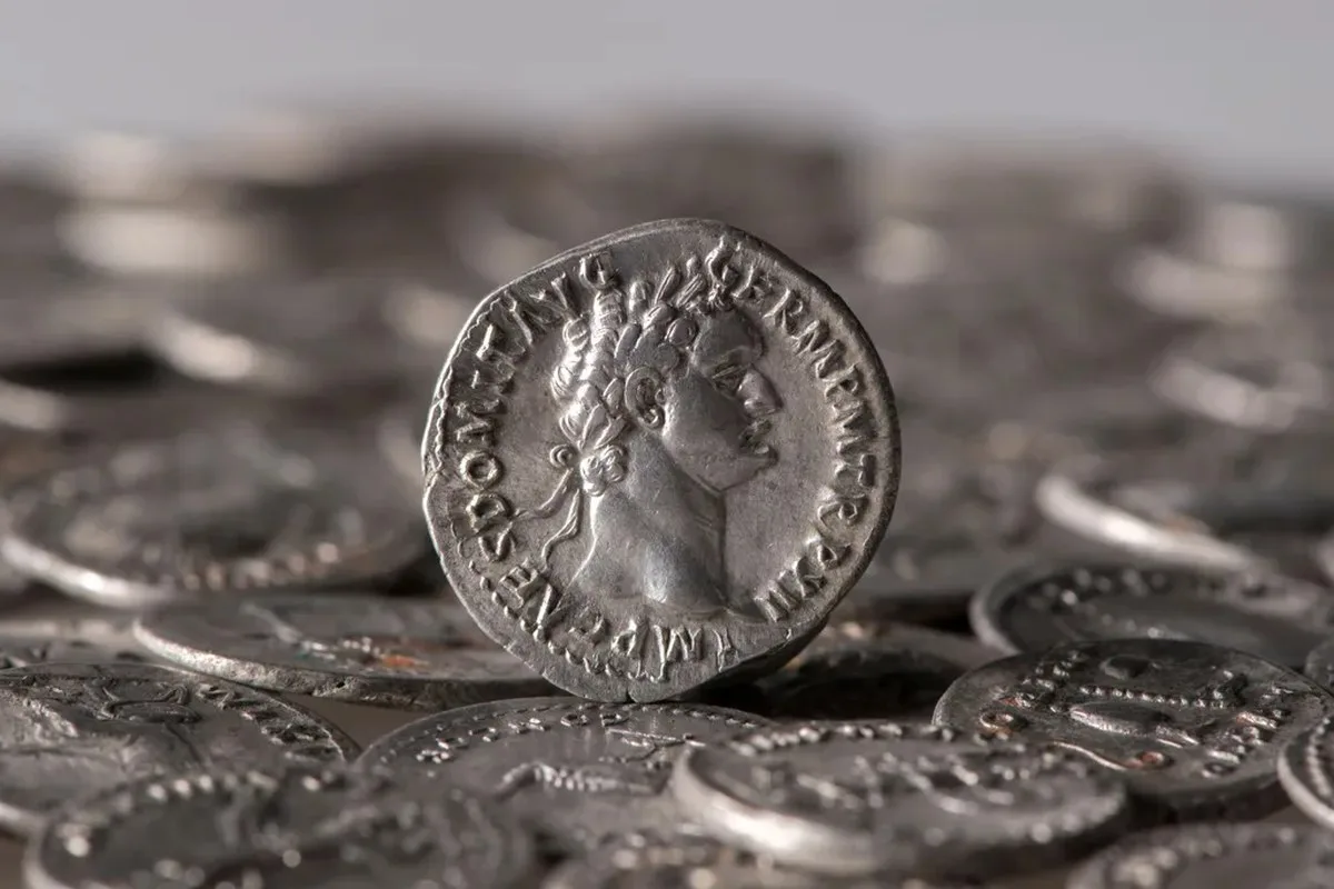 A Roman coin perched on top of other coins