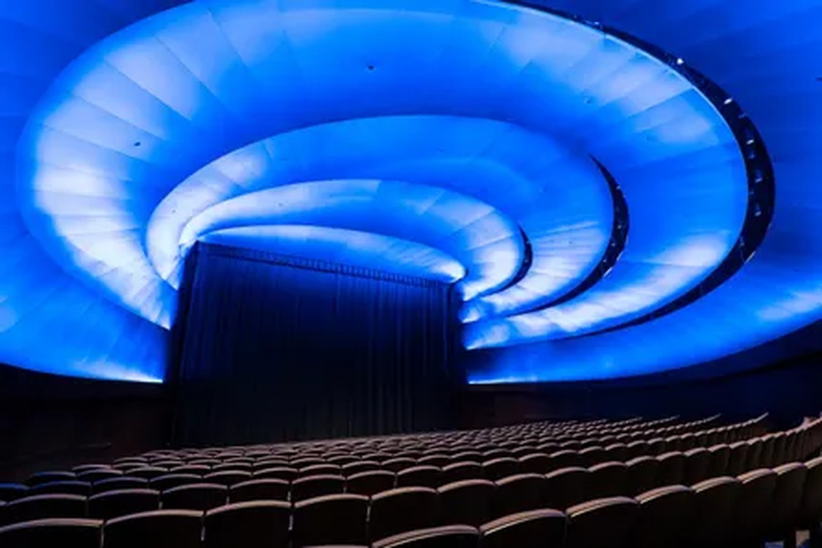 a dark theater with blue swirl lighting on the ceiling