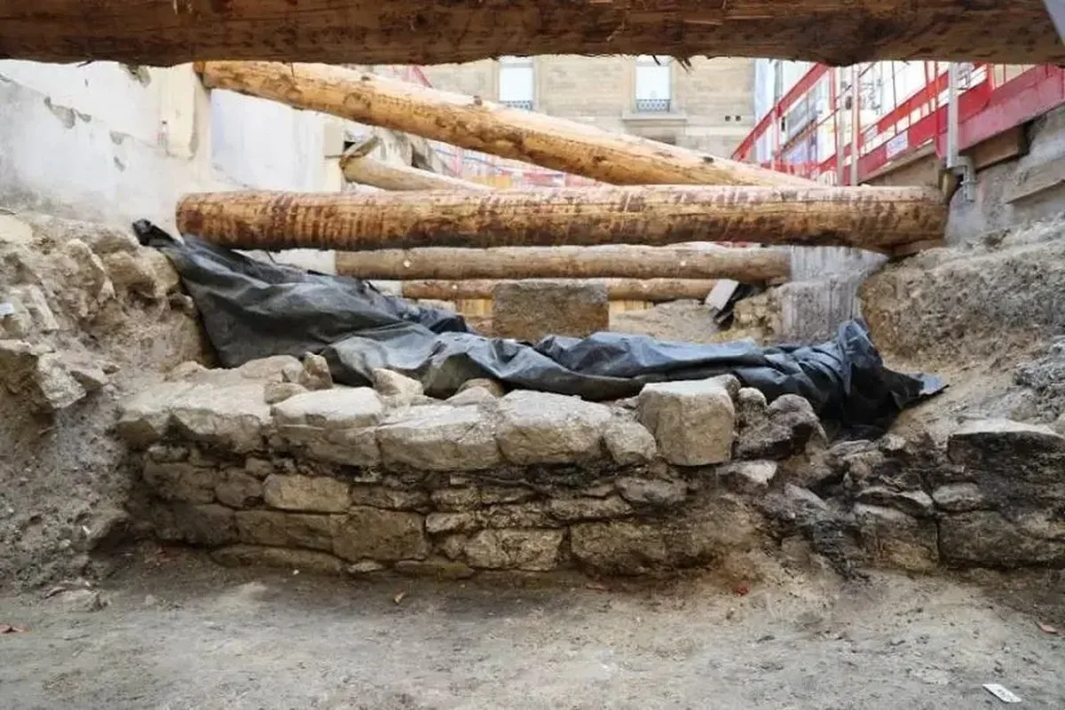 A view of a historic wall made of stone with some wooden beams behind it