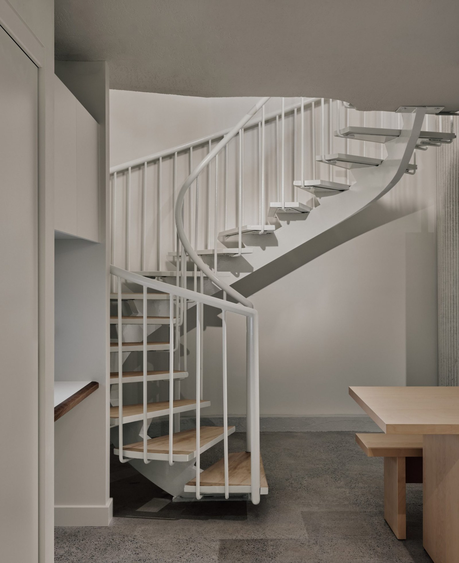A spiral staircase leads down to a staff area in a basement