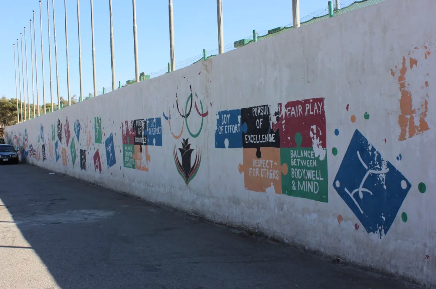 Colorful messages of sportsmanship fade on Sports City’s walls. 