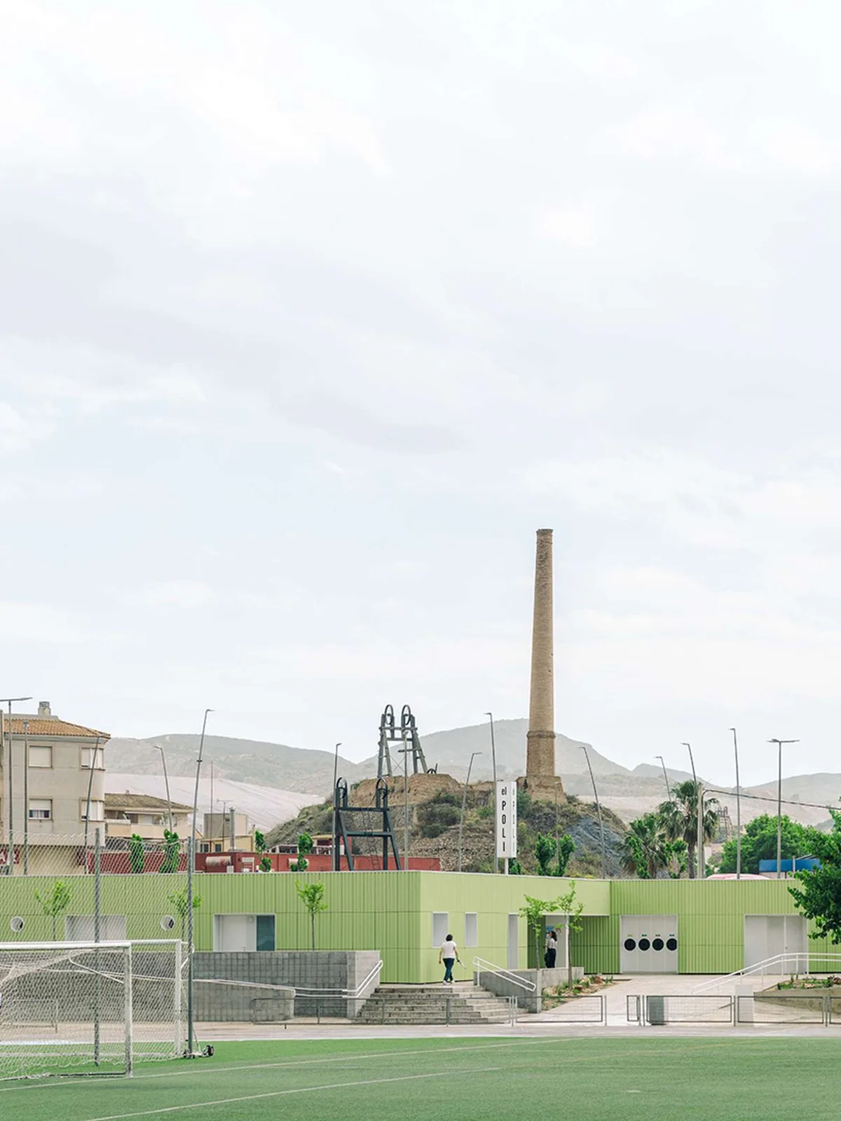 ribbed lime-green gateway and blue solar canopy reform municipal sports center in spain - 1