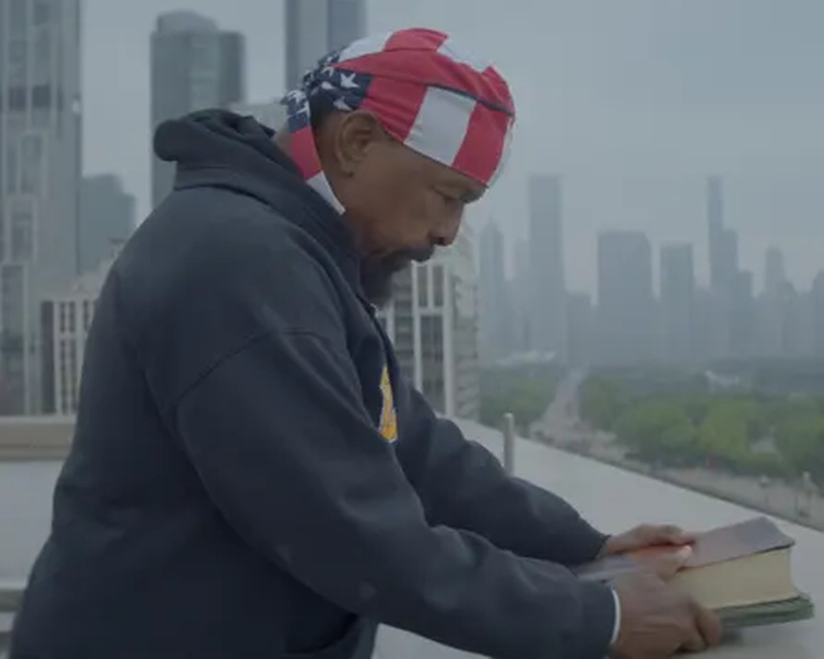 Mr T on a balcony holding a book