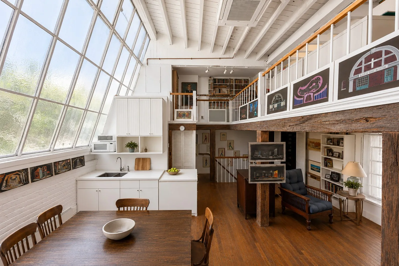 a room from a house on MacDougal Alley with large window and lots of light, wooden floors and a wooden table