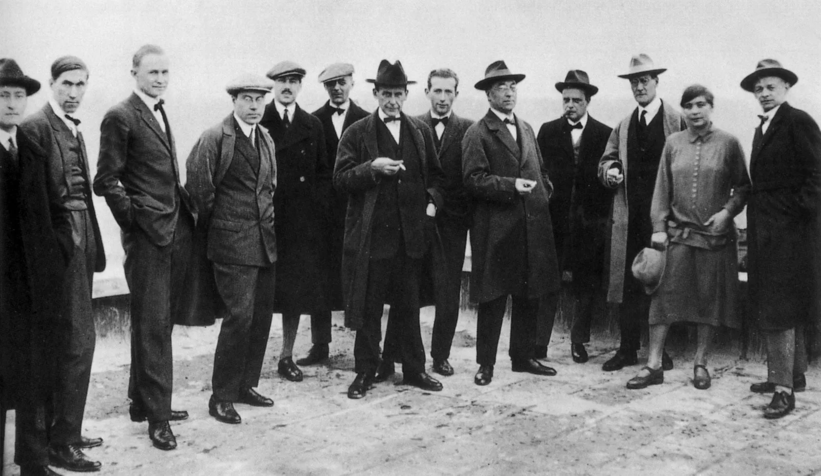 a group of man and one woman on a roof in a black and white image