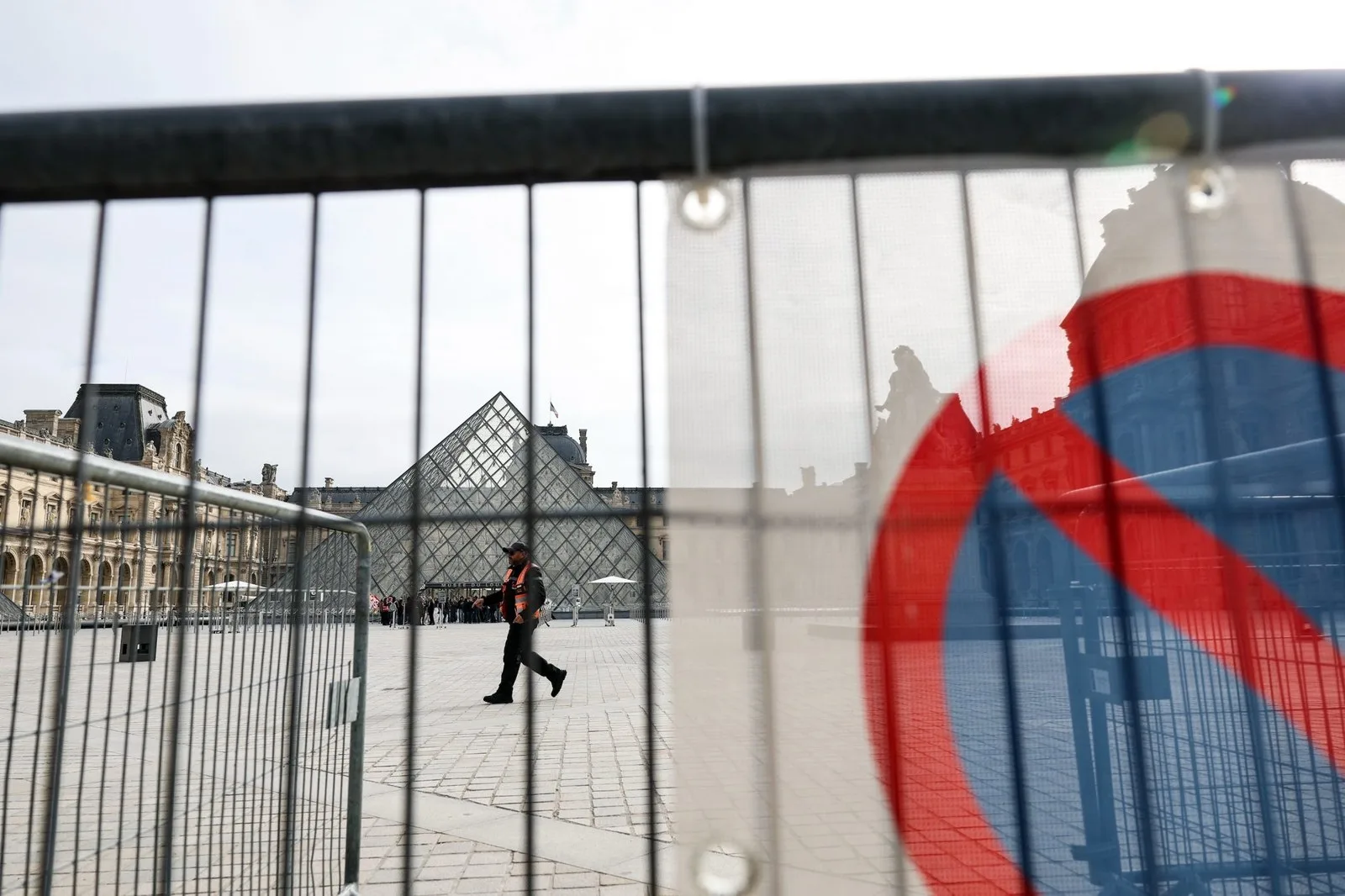 railing with the stop sign in front of the Louvre
