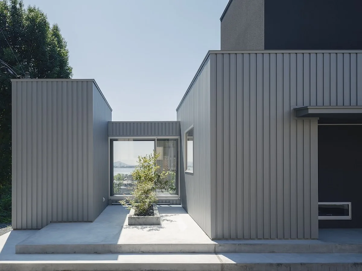 glazed passage frames lake views through this compact japanese house - 2