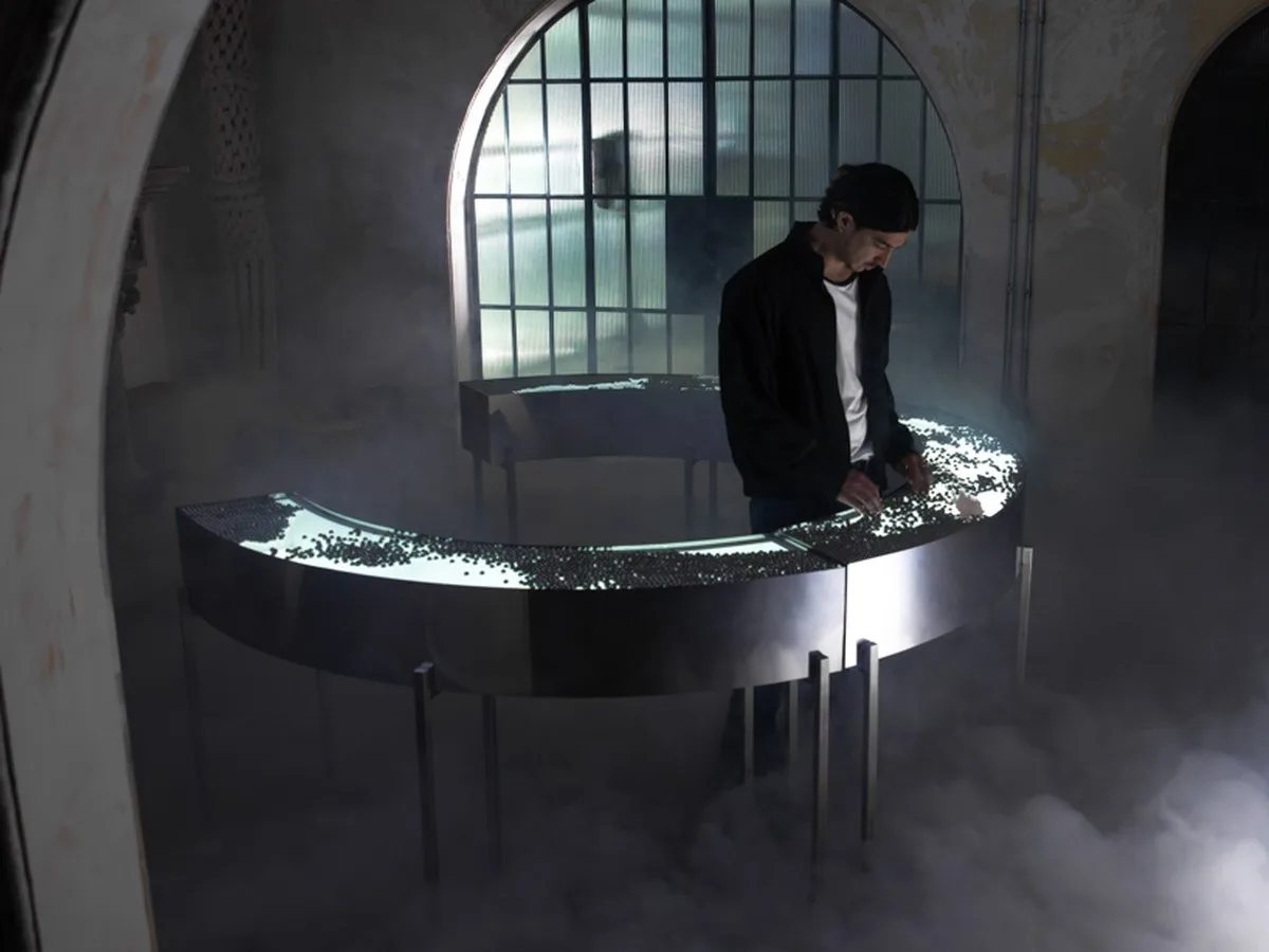 steel spheres moving across curved glass frame leonardo garza’s sensory installation for BYREDO - 1