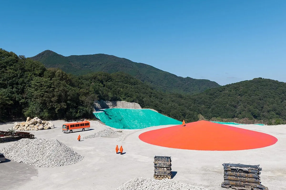 ryue nishizawa places vivid orange peak against turquoise landfill in japan - 2