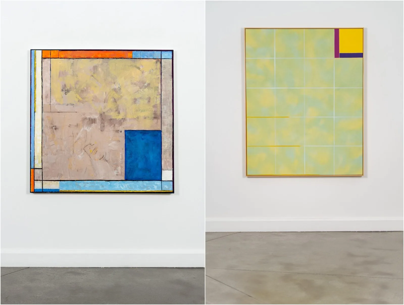 Two abstract paintings hang side by side in a white gallery with a concrete floor. On the left, a square canvas has a muted, scraped surface in tan and pale yellow, framed by a border of orange, light blue, white and yellow bands, with a bold blue rectangle in the lower right. On the right, a taller canvas in a pale wooden frame has a soft, cloudy yellow-green field crossed by a grid of thin white lines, with a purple, yellow and indigo block in the upper right corner. Included in the Oeno Gallery group show Constructing Space in Toronto.