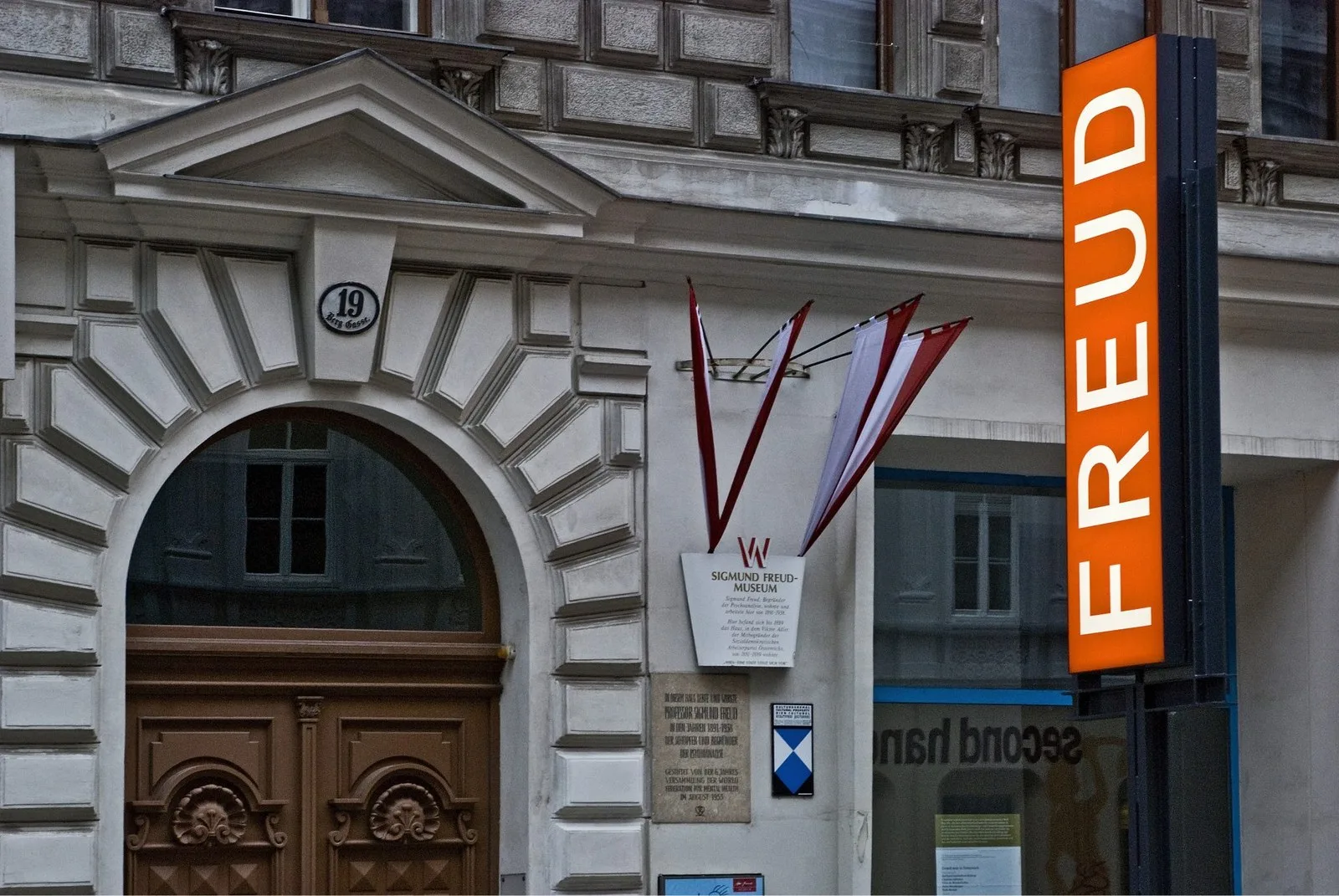 Exterior of Vienna’s Sigmund Freud Museum, featuring an ornate stone facade, entrance, and orange signage.